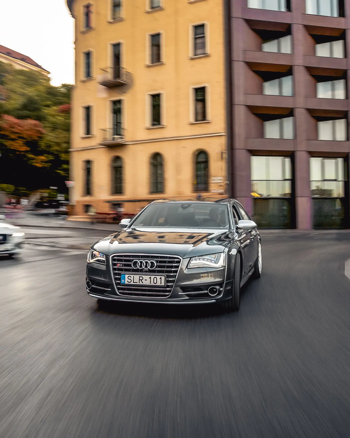 Grey Audi S8 on a city street, apartment buildings behind