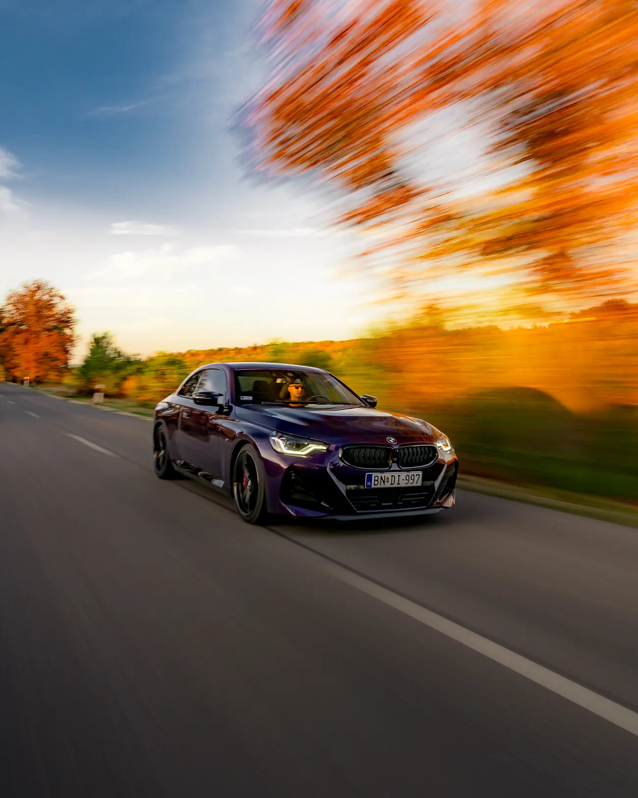 BMW M240i at sunset, an orange tree blurred above it