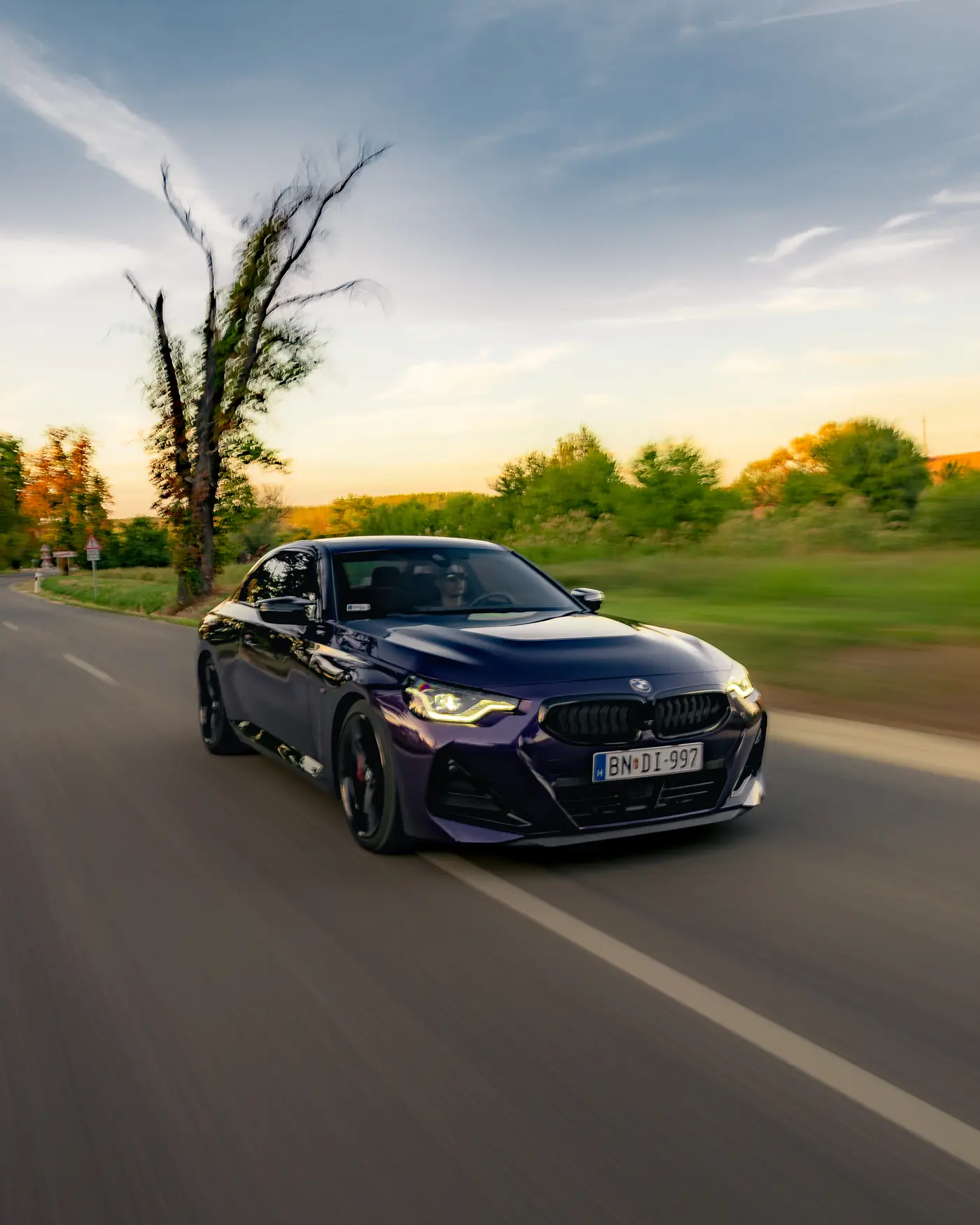 BMW M240i on a country road under an evening sky